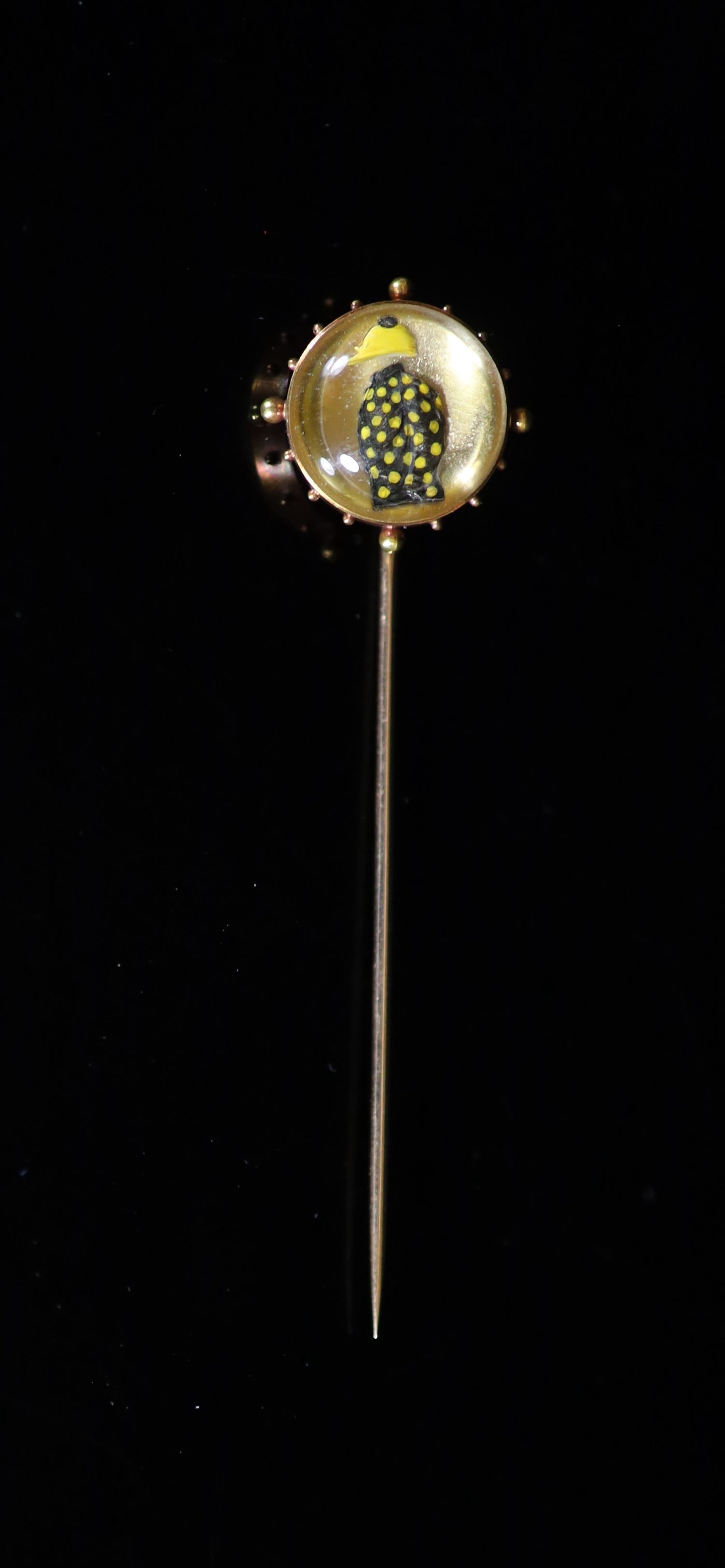 A late 19th century French 18ct gold and Essex crystal stick pin decorated with jockeys colours, see lot for related items